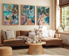 three paintings hang on the wall above a couch in a living room with a coffee table