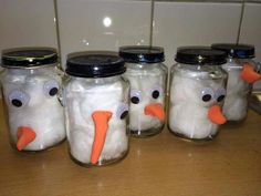 four glass jars with fake snowmen in them