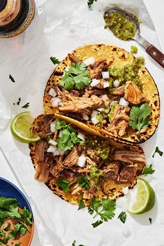 two tacos with meat, cilantro and green salsa