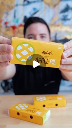 a woman holding up an apple pie box