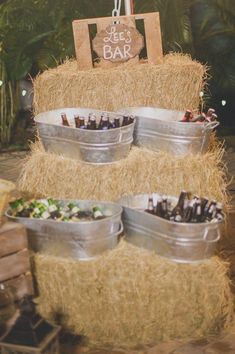 there are several buckets that have food in them on top of the hay bale