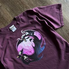 a purple shirt with an image of a witch on it