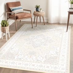 a living room area with a rug, chair and potted plant