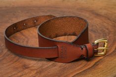 a brown leather belt sitting on top of a wooden table