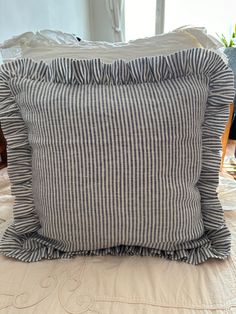 a pillow with ruffled edges sitting on top of a bed