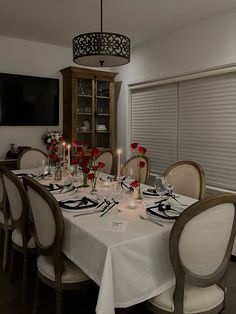 a dining room table is set with white linens and place settings for eight people