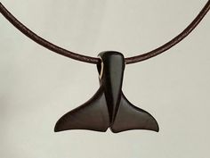 a brown necklace with a black pendant hanging from it's side