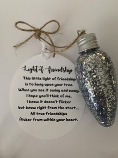 a glass bottle with a poem on it next to a tag that says light of friends