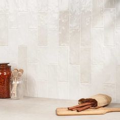 some cinnamon sticks are sitting on the counter next to jars and spoons in front of them