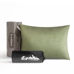 a green pillow sitting next to a black bag