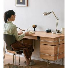 a woman sitting at a desk with a lamp on it