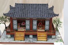 a model of a chinese house with steps leading to the front door and stairs up to the second floor