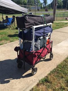 a cart with luggage sitting on top of it next to a sidewalk near a park