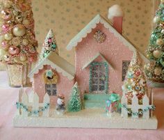 a pink and white christmas village with trees