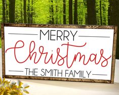 a merry christmas sign with the words, the smith family on it and flowers in front