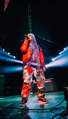 a man standing on top of a stage holding a microphone in front of his face