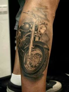 a man's leg with a motorcycle tattoo on it