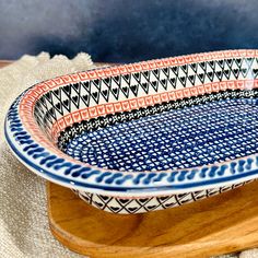 a blue and white bowl sitting on top of a wooden table next to a cloth