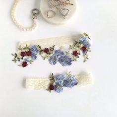 This beautiful stretch lace Wedding garter set is made with blue embroidered flowers, green leaves and stretch lace with burgundy, blue, silver or gold flowers. Custom sized just for you and comes in a gift box.  Choose your lace color (secondary color) and small flower color (primary color). Any color combination will still have the larger blue flowers and green leaves. MEASURING INSTRUCTIONS: Use a soft tape measure or string and ruler. Measure where you want to wear your keepsake (the larger) garter. Measure a bit snug, not too tight or too loose. Order your actual measurement and I will take some off so it stretches to fit. The toss garter will be made smaller than the keepsake. SHIPPING: Each item is custom handmade to order and will ship out 3-5 business days after you order. Then sh Lace Wedding Garter Set, Lace Wedding Garter, Lace Bride, Wedding Garter Set, Wedding Garters, Garter Set, Garters, Something Blue, Embroidered Lace