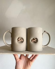 two coffee mugs that have been made to look like they are being held together