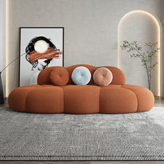 a living room with an orange couch and art on the wall