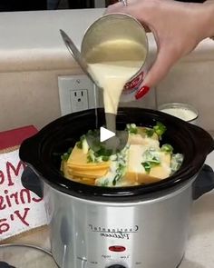 a woman pouring cheese into a slow cooker