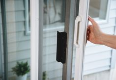 a person is holding the door handle on a sliding glass door