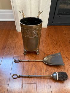 an old fashioned metal bucket and shovel on the floor