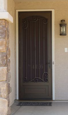 the front door to a home with an iron gate and sidelights on either side