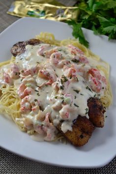 a white plate topped with pasta and meat covered in gravy next to parsley