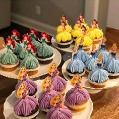 some cupcakes that have been decorated to look like disney princesses on them