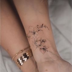 two women's feet with tattoos on them, one has a flower tattoo on the other