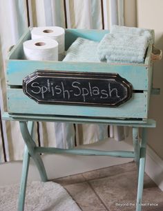 a wooden box with some toilet paper on it and a sign that says splish - splash