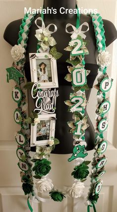 a mannequin is decorated with green and white ribbons, flowers, and photos