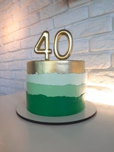 a green and white cake sitting on top of a table next to a brick wall