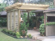 a wooden gazebo surrounded by greenery in a backyard area with trees and shrubs