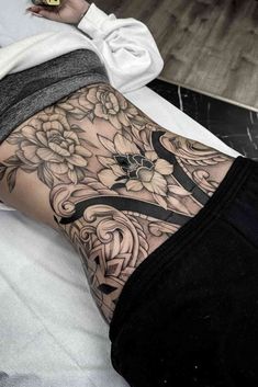 a woman's leg with flowers on it and a cross tattoo design in the middle