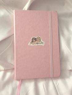 a pink notebook with an image of two children on it