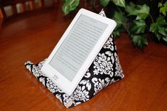 an electronic device sitting on top of a black and white pillow next to a potted plant