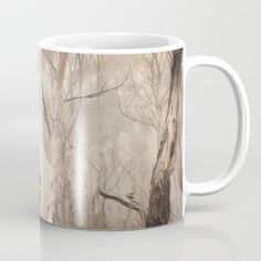 a coffee mug with trees and fog in the background