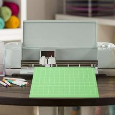 a cricut machine sitting on top of a table next to some crayons