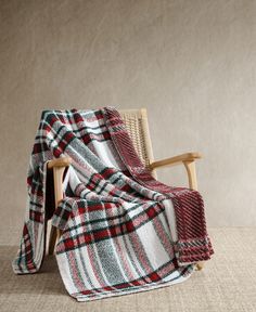 a chair with a plaid blanket on it and a wooden rocking chair in the background