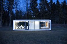 a house made out of shipping containers sitting in the middle of a field at night