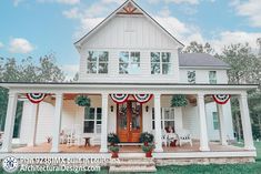 a white house with red, white and blue decorations on it's front porch