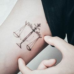 a woman's arm with a tattoo on it that has an hour and hourglass