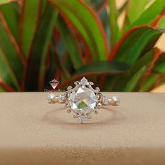 a diamond ring sitting on top of a table next to a potted green plant