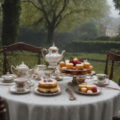 a table topped with plates and cups filled with desserts next to a tea kettle