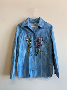 "Vintage Embroidered Two Piece Denim Pant & Jacket Set with butterfly and floral stitched detail.  Button Up Measurements Size No tag fits like Med/Large Length  27\" Shoulder to shoulder  17.5\" Pit to pit  19\" Sleeve  22\" Pants (measured laying flat) Measurements Size Tag hard to read, maybe size 16 Waist  14.5\" Inseam to Waist  14\" Inseam to ankle 29.5\" Ankle width. 11\"" Embroidered Long Sleeve Denim Jacket For Summer, Embroidered Long Sleeve Summer Denim Jacket, Vintage Long Sleeve Denim Jacket For Spring, Fitted Jeans With Buttons For Spring, Vintage Floral Embroidered Jeans For Spring, Button-up Cotton Jeans For Spring, Vintage Embroidered Denim Jacket For Spring, Vintage Cotton Jeans For Spring, Summer Outerwear With Floral Embroidery In Medium Wash