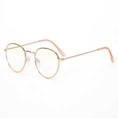 a pair of glasses sitting on top of a white surface with gold rims and clear lenses