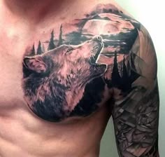 a man's chest with a wolf tattoo on it and mountains in the background